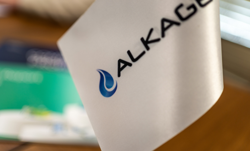 A close-up view of a white item displaying the Alkagesta logo with a blue droplet icon.