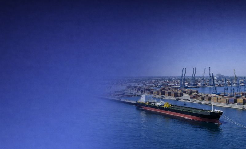 A cargo ship is docked at a busy port with cranes and shipping containers. Most of the image is overlaid with a blue gradient, leaving only a section with the ship and port visible.