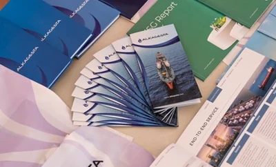 A table displaying several brochures, booklets, and printed materials arranged in overlapping rows.
