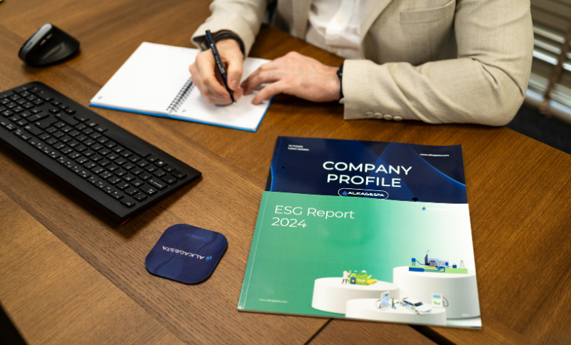 Alkagesta Company Profile and ESG Report 2024 documents on office desk with professional taking notes alongside Alkagesta branded coaster