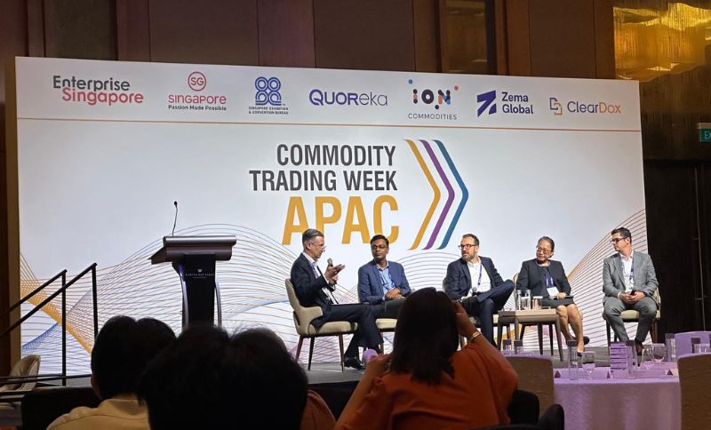 Conference panel at Commodity Trading Week APAC with multiple speakers seated on stage in front of a branded event backdrop while attendees watch from the audience.