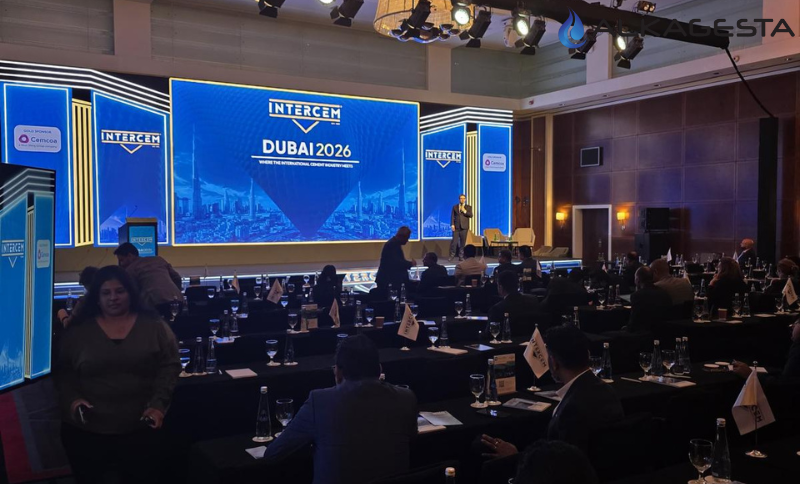 Conference hall with attendees seated at tables facing a large stage displaying INTERCEM Dubai 2026 graphics and presentation screens.
