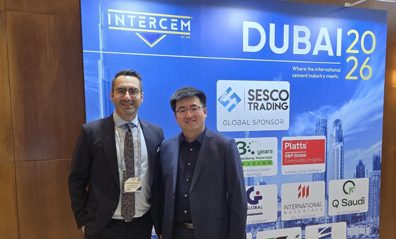 Two individuals in business attire standing in front of an INTERCEM Dubai 2026 event backdrop displaying sponsor logos and a city skyline graphic.