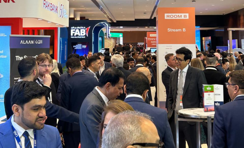 Business professionals networking at a financial conference exhibition in Dubai