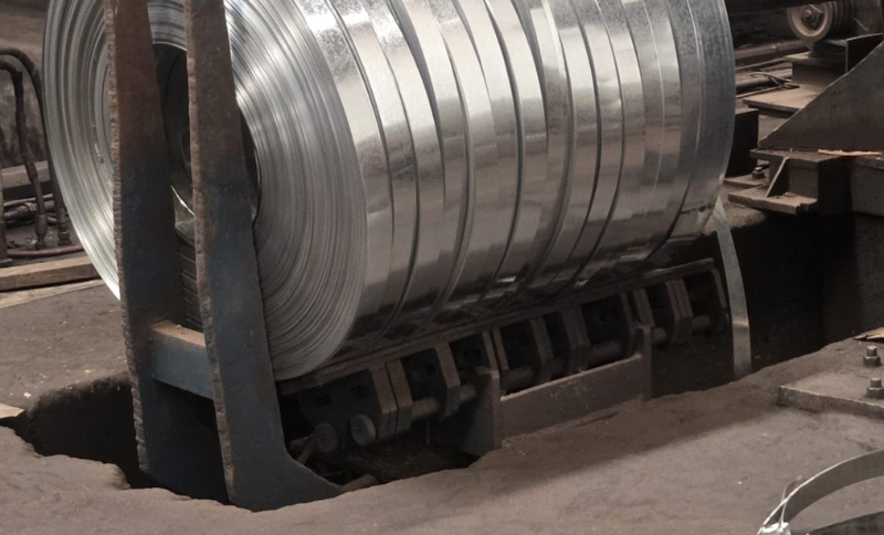 Large rolled metal coil mounted on industrial processing equipment inside a manufacturing workshop during Alkagesta’s West Africa site visit.