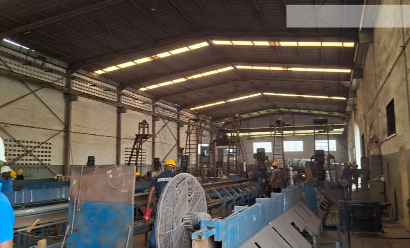 Industrial workshop with metal‑processing machinery and workers operating equipment during Alkagesta’s West Africa site visit.”