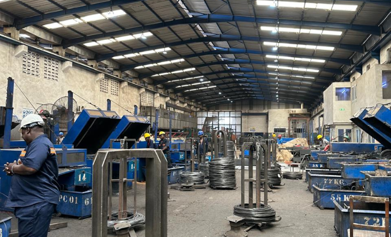 Industrial fabrication workshop with metal components, machinery, and workers during Alkagesta’s strategic West Africa site visit.