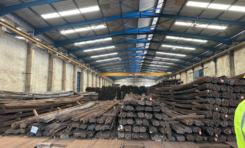 bundled steel rods and reinforcement bars stored inside industrial warehouse facility