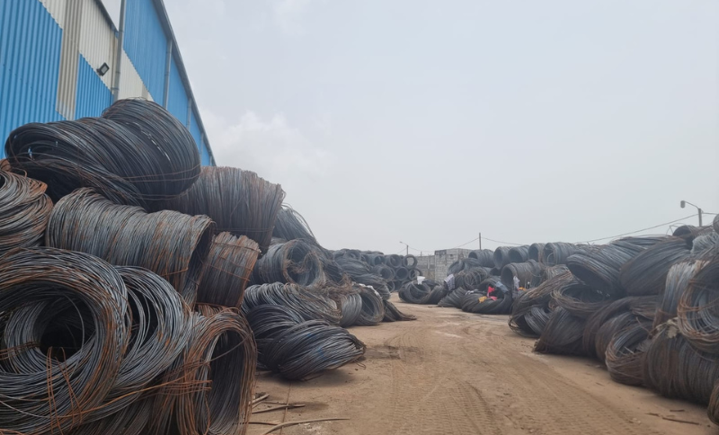 steel wire coils stacked in industrial yard at West Africa facility during Alkagesta site visit
