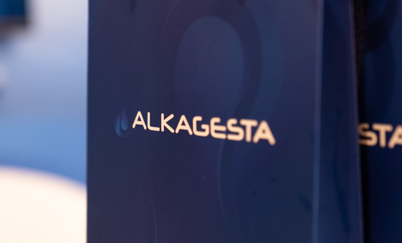 Close‑up view of the Alkagesta branded banner displayed at a corporate event.