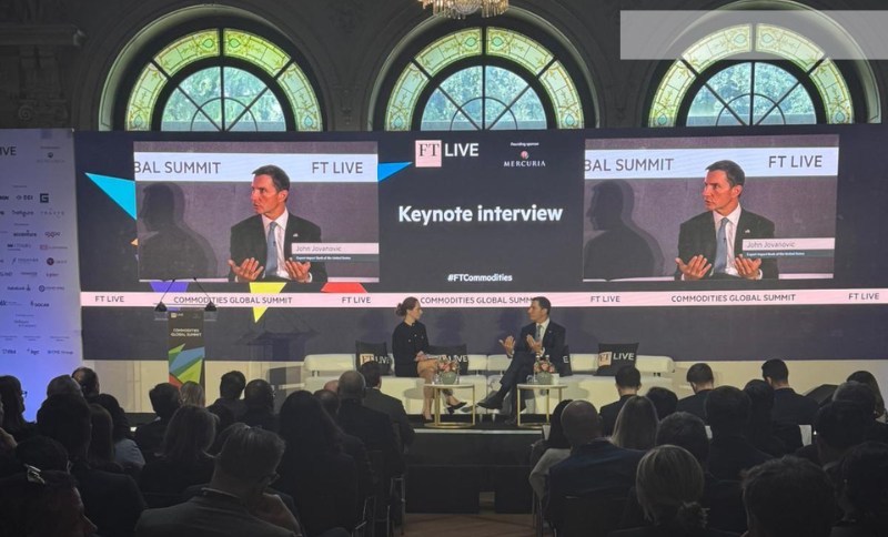 A keynote interview session taking place on the main stage of the FT Commodities Global Summit, showing a speaker seated on stage with large presentation screens behind displaying the session title and event branding.