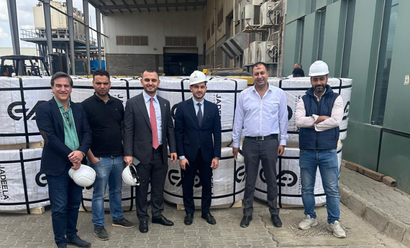 Alkavex delegation with local partners standing near packaged steel products at an industrial facility in Cairo.