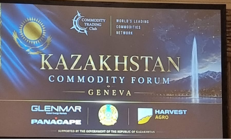 A promotional screen for the Kazakhstan Commodity Forum in Geneva, featuring the Kazakh flag, a fountain, event sponsors, and the Commodity Trading Club logo, with text highlighting Kazakhstan as a world’s leading commodities network.