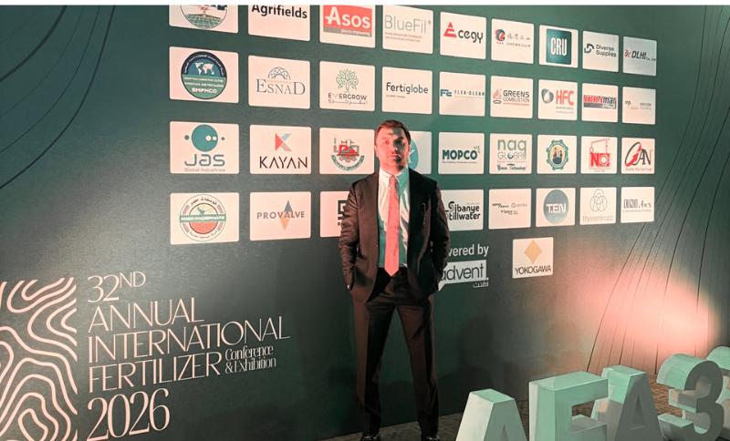 A man in a suit stands in front of a green backdrop with sponsor logos at the 32nd Annual International Fertiliser Conference & Exhibition 2026.