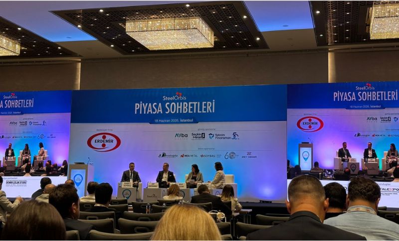A conference panel in a large hall with four speakers seated on stage and an audience watching. The backdrop displays SteelOrbis Piyasa Sohbetleri and various sponsor logos.