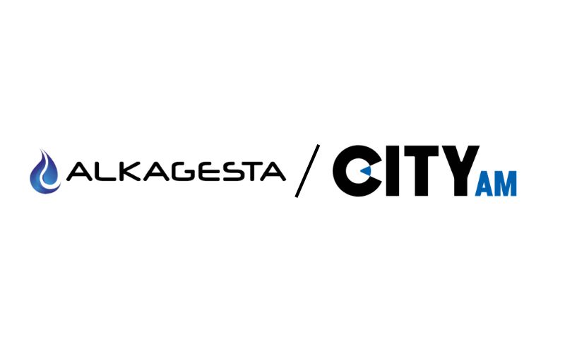 Alkagesta logo with a blue water droplet icon next to text, separated by a slash from the CITY AM logo, which has bold black and blue letters.