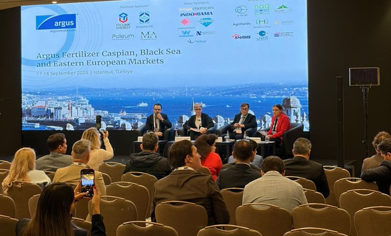 Panellists sit on stage at a conference titled Argus Fertiliser Caspian, Black Sea and Eastern European Markets in Istanbul, with an audience seated and cityscape backdrop.