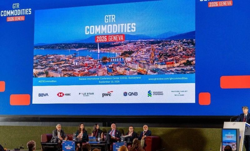A panel of five people sits onstage beneath a large screen displaying GTR Commodities 2026 Geneva with an aerial photo of Geneva. Logos of several sponsors are also visible on the screen.