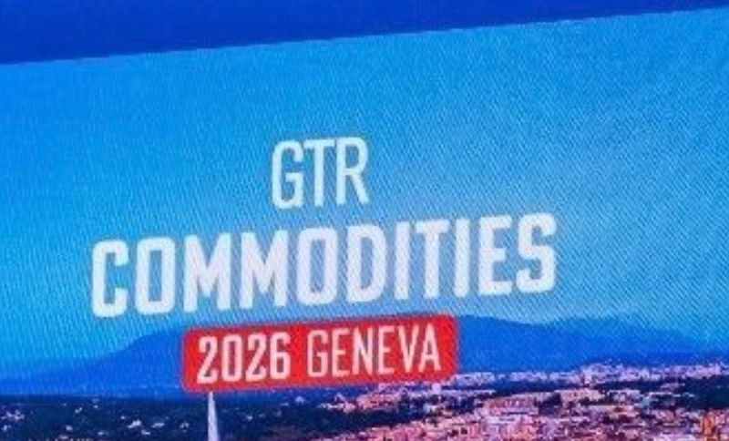 A sign reads GTR COMMODITIES 2026 GENEVA against a blue sky with mountains and part of a city visible at the bottom.