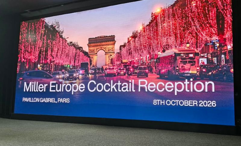 Digital screen displaying an event invitation for the Miller Europe Cocktail Reception at Pavillon Gabriel, Paris, on 8 October 2026, set against a photo of the Arc de Triomphe illuminated by red lights.