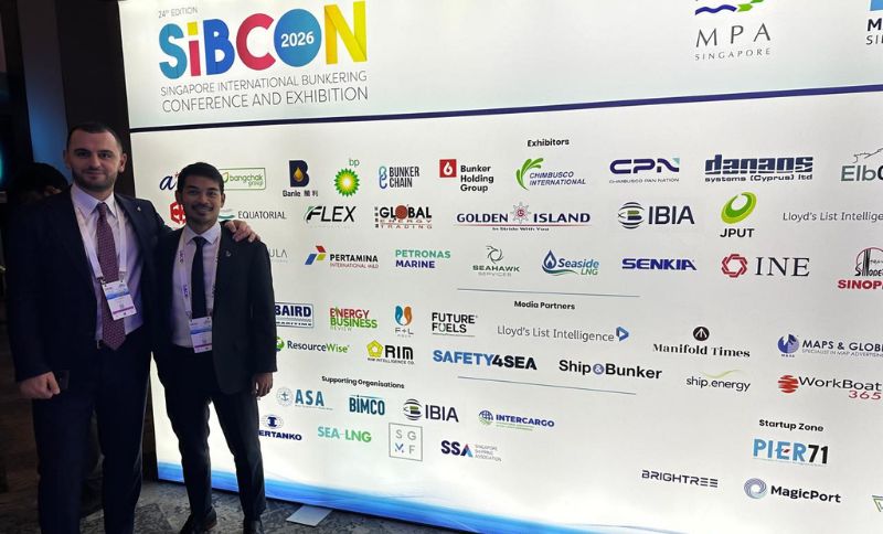 Two men in suits stand in front of a SIBCON 2026 conference backdrop featuring various corporate sponsor and media partner logos.